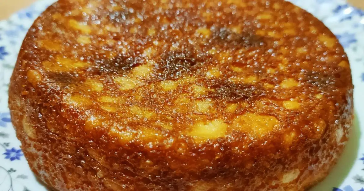 Freshly baked Chhena Poda resting on a cooling rack, the surface golden and slightly cracked, embodying a rustic charm.