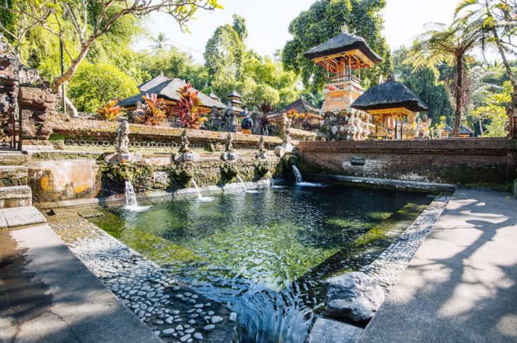 Pemandangan candi-candi Pura Gunung Kawi yang dipahat langsung pada tebing batu, dikelilingi oleh alam hijau yang asri