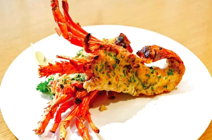 Lobster bakar keju yang creamy dengan lelehan keju mozzarella di atas daging lobster yang lembut